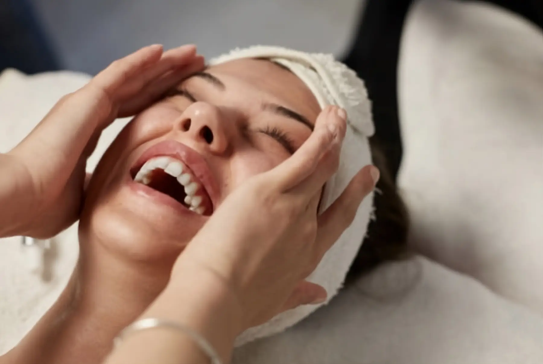 Femme souriante pendant un massage du visage