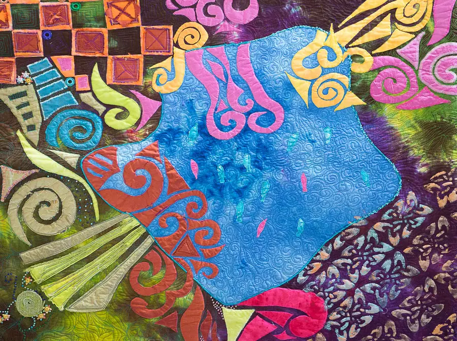 Art quilt with swirls in blue and orange