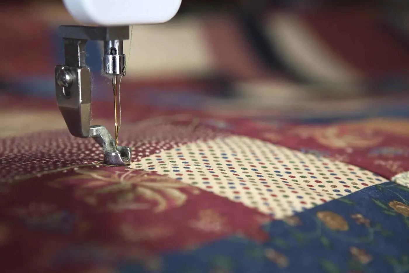 Sewing machine needle stitching patterned fabric